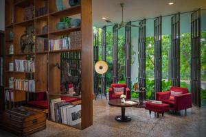 a living room with red chairs and bookshelves at Viroth's Hotel in Siem Reap