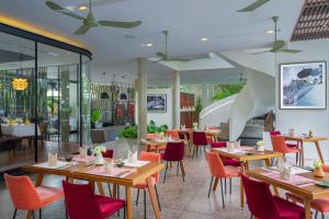 a restaurant with wooden tables and red chairs at Viroth's Hotel in Siem Reap