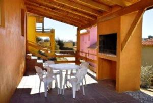 a patio with a table and chairs on a house at Cabañas Wairoa Haus in Villa General Belgrano