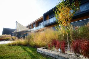 a building with tall grass in front of a building at Hotel Bonifacio SPA&SPORT Resort in Sochocin
