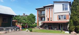 a large brick house on a street at Spacious & Cozy Apartment with Forest View in Zapyškis