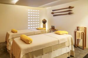 two beds in a room with yellow pillows on them at Viroth's Hotel in Siem Reap