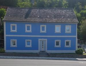 a blue house with a gray roof at Ferienwohnung N plus B in Mitwitz