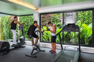 a group of three people exercising on exercise bikes in a gym at Viroth's Hotel in Siem Reap
