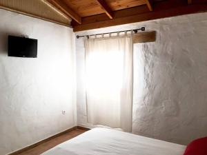 a bedroom with a bed with a window and a television at La Carpintería nature relax in Tefía