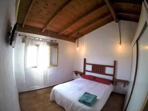 a bedroom with a white bed with a window at La Carpintería nature relax in Tefía