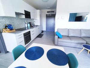 a kitchen and a living room with a table and chairs at Apartamenty Relaks & Spa Pięć Mórz in Sianozety +37 photos