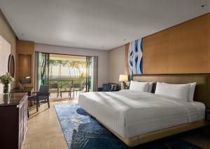 a bedroom with a large bed and a living room at Shangri-La Tanjung Aru, Kota Kinabalu in Kota Kinabalu