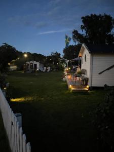 a backyard at night with a house and a fence at Ölandspärlan 2 in Färjestaden +17 photos