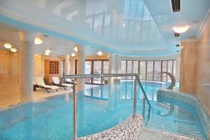 a large swimming pool in a building with at Retro Riverside Wellness Resort in Karlovy Vary