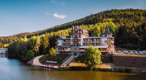 a large building on the side of a river at Retro Riverside Wellness Resort in Karlovy Vary +37 photos