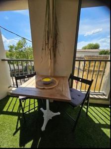 a table and a chair on a balcony at Au petit coeur de l'isle in LʼIsle-sur-la-Sorgue