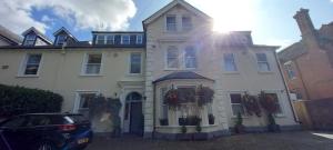 Una casa blanca con un coche aparcado delante. en canterbury lodge, en Kent