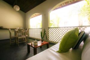 a room with a bed and a balcony with a table at Flor da Mata in Pipa +37 photos