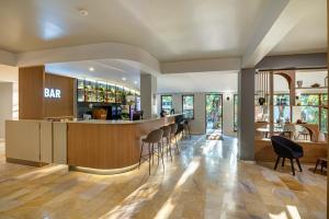 eine Bar in einem Restaurant mit Stühlen und Tischen in der Unterkunft Hotel PRESLAV in Goldstrand