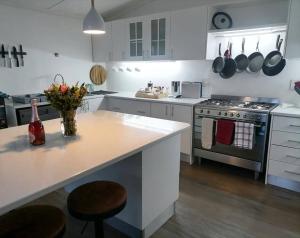 a kitchen with a stove and a counter with flowers at Milner Meander in Grahamstown