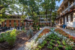 ein Garten mit Blumen vor einem Gebäude in der Unterkunft Hotel PRESLAV in Goldstrand