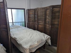a bed in a room with wooden walls and bunk beds at 宿坊かつら in Izu