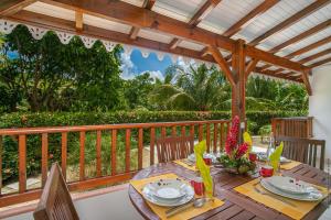 a wooden deck with a table and chairs at Balisier au Refuge de Madiana à Schoelcher in Schœlcher