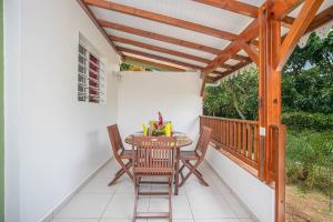 a patio with a wooden pergola and a table and chairs at Balisier au Refuge de Madiana à Schoelcher in Schœlcher