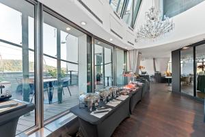 una fila di tavoli in una stanza con finestre di Dancing House - Tančící dům hotel a Praga