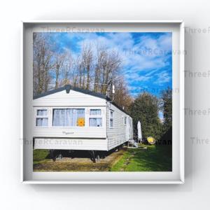 a white tiny house sitting on top of a field at ThreeRCaravan, Green Lawn - relaxed rhythmic rejoice in Selsey