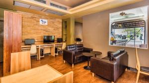 a waiting room with leather chairs and a desk with a computer at Sunset Mansion in Patong Beach
