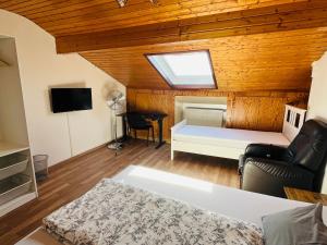 a living room with a bed and a skylight at FerienWohnung A&S Heuchelheim in Heuchelheim