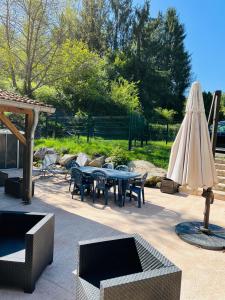 a patio with a table and an umbrella and chairs at La casa di Alba-Salomé in Métairies-Saint-Quirin +40 photos