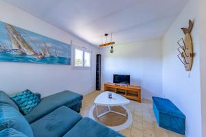 a living room with a blue couch and a table at Sun Résidences Horizon Bleu in Vendres