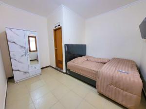 Postel nebo postele na pokoji v ubytování Wahyu Putri House Yogyakarta