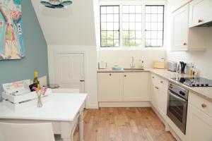 a kitchen with white cabinets and a white counter top at Divine in Georgeham