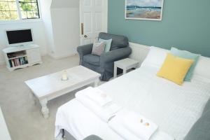a living room with a white bed and a chair at Divine in Georgeham