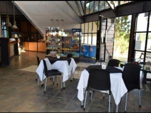 a restaurant with two tables and chairs with white table cloth at Apart , Descanso y Bienestar in San Pedro