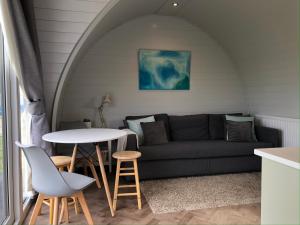 a living room with a couch and a table at Sandy Meadow Escapes in Lairg