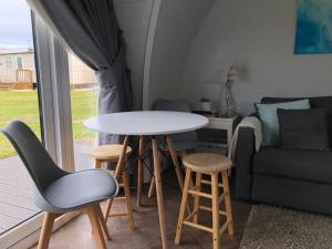 a room with a table and chairs and a couch at Sandy Meadow Escapes in Lairg
