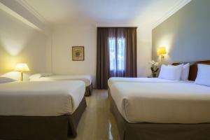 a hotel room with two beds and a window at Crisol Jardines de Córdoba in Córdoba