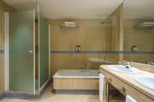 Un baño con bañera, lavabo y ducha. en Crisol Jardines de Córdoba, en Córdoba