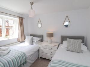 a bedroom with two beds and a dresser at Adventure Cottage in Whitby