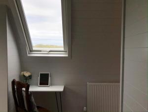 a skylight in a bathroom with a window at Sandy Meadow Escapes in Lairg