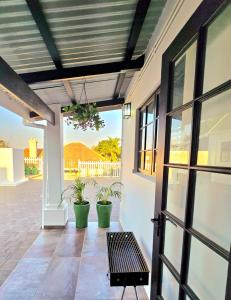 a porch with a bench and potted plants at Hampton Collection Avenues - Cosy 2 Sleeper Studio Apartment in Durban