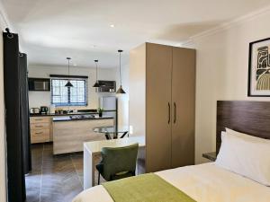 a hotel room with a bed and a kitchen at Hampton Collection Avenues - Cosy 2 Sleeper Serviced Studio Apartment in Durban