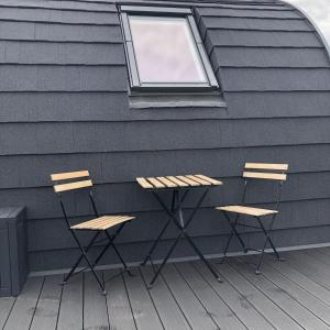 two chairs and a table against a wall with a window at Sandy Meadow Escapes in Lairg
