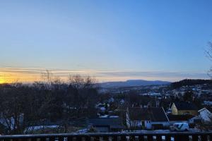 a view of a city with the sun setting at 7 min to Ski Championship, Glass front house, Terrace in Trondheim
