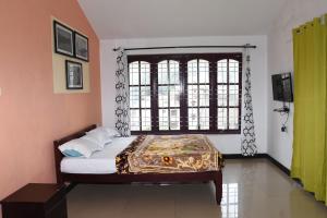 a bedroom with a bed and a large window at Elk Hill Palace in Ooty