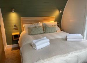 a bedroom with a bed with towels on it at Sandy Meadow Escapes in Lairg