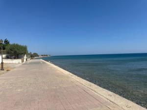 a pathway leading to the ocean on a clear day at Poppis Apartments in Ierapetra +6 photos
