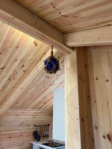 a ceiling of a wooden cabin with a chandelier at Sandy Meadow Escapes in Lairg