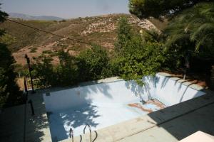 an empty swimming pool with a hill in the background at Cosy Villa in Pikérmion