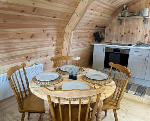 a dining room with a table and chairs in a kitchen at Sandy Meadow Escapes in Lairg